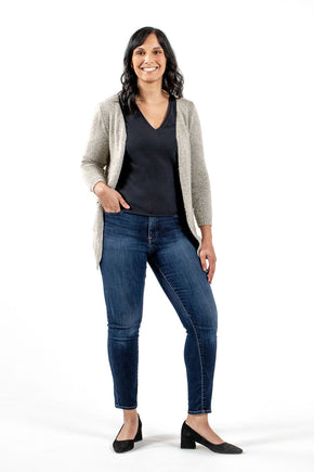 woman in sustainable black blouse with cream cardigan, jeans, and low heels